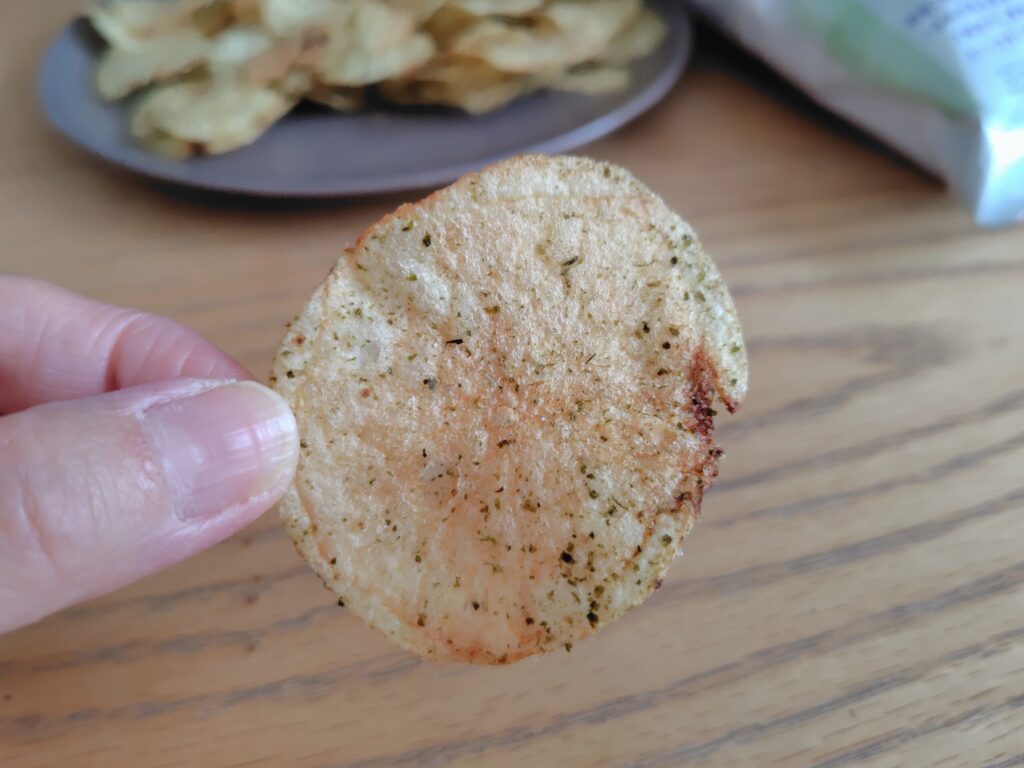 一枚手で持ったこめ油で揚げたポテトチップス