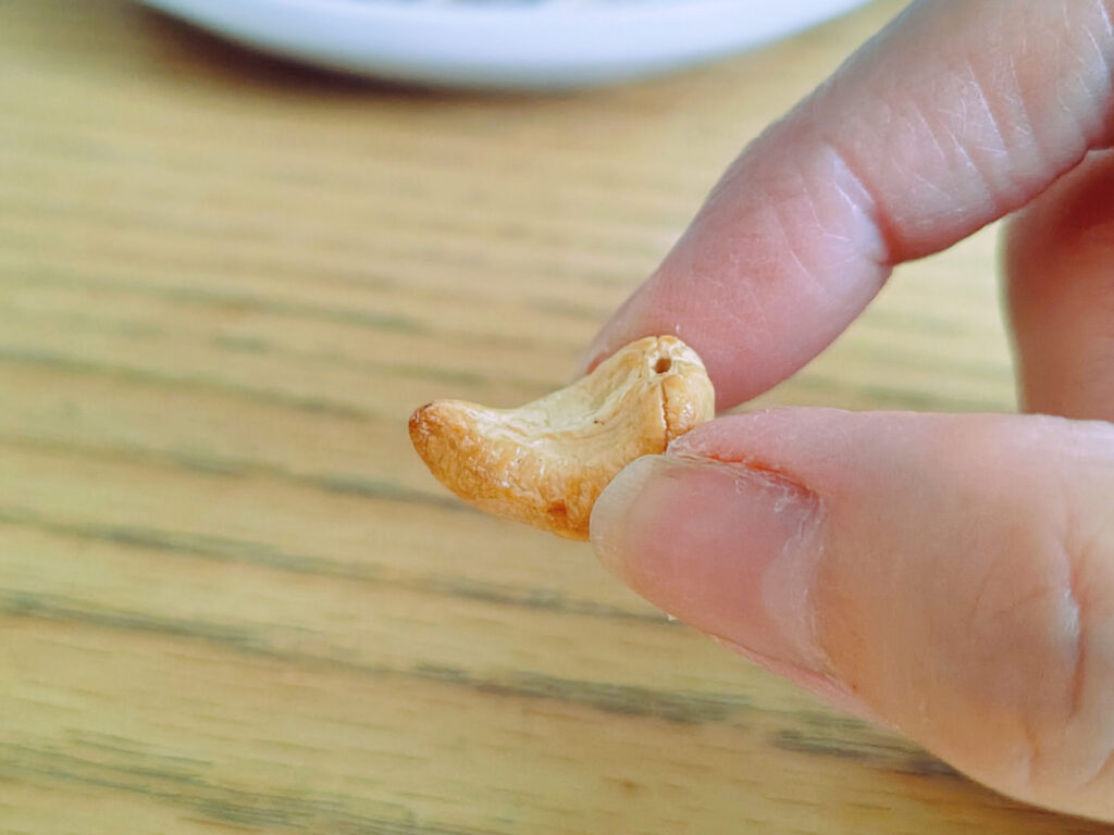 手でつまんだカシューナッツ