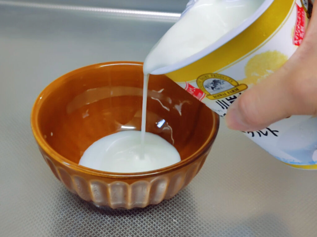 容器を傾けて器に注いでいる