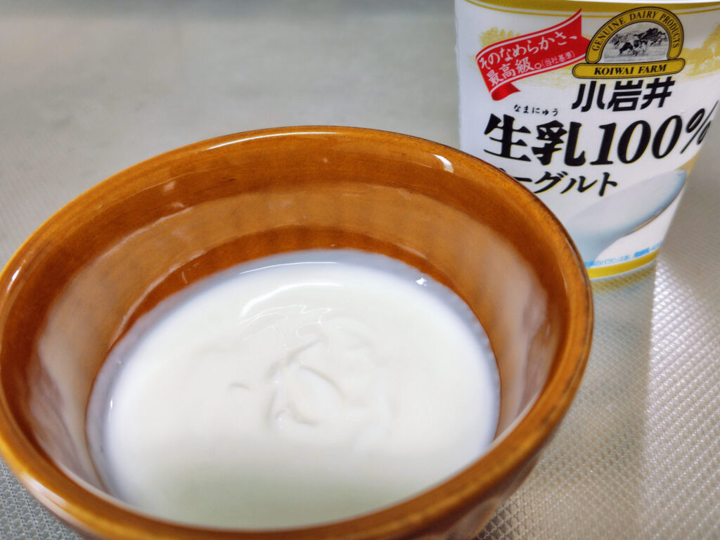 お皿に入れた生乳100%ヨーグルトとパッケージ