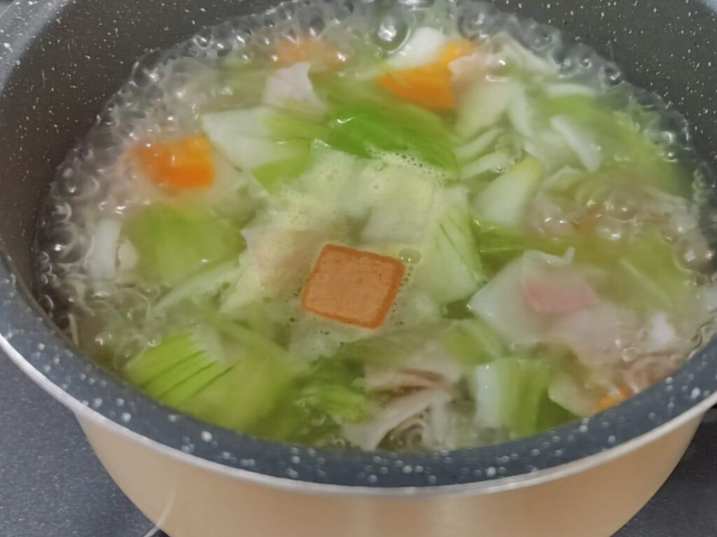 野菜スープの鍋に入れたコンソメ